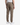 A person is shown from the back, standing against a white background and wearing the PROJEK RAW SOLID BUNGEE CARGO RELAXED FIT PULL ON JOGGER in tan, paired with white sneakers. These jogger pants offer a relaxed fit with stretch fabrication, flap pockets, and elastic cuffs at the ankles.