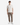 A person stands facing forward against a plain white background, wearing a plain white short-sleeve t-shirt paired with the PROJEK RAW SOLID BUNGEE CARGO RELAXED FIT PULL ON JOGGER, which features tan coloring, drawstrings, cargo pockets, and stretch fabrication for a relaxed fit. The look is completed with white sneakers.