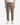 A person is wearing the PROJEK RAW SOLID BUNGEE CARGO RELAXED FIT PULL ON JOGGER in light brown, featuring side pockets and stretch fabrication for extra comfort and a relaxed fit, paired with a white t-shirt and white sneakers while standing against a plain white background.
