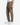 A person wearing PROJEK RAW SOLID BUNGEE CARGO RELAXED FIT PULL ON JOGGER pants in light brown, styled with side pockets, paired with a white shirt and white sneakers, stands against a plain white background.