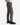 A person wearing PROJEK RAW TEXTURED BUNGEE CLASSIC FIT CHINO PANT in olive-green, paired with a light sweater and black sneakers, stands against a white background, shown from the side and waist down.