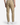 A person shown from the back stands against a white background, effortlessly styled in PROJEK RAW’s CAVALRY TWILL BUNGEE CHINO PANTS paired with white sneakers—a versatile look that moves easily from casual outings to office settings.