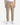 A person wearing the PROJEK RAW CAVALRY TWILL BUNGEE CHINO PANTS in tan, paired with a white tucked-in shirt and white sneakers, stands against a plain white background—a smart example of modern office dressing.