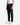 A man stands wearing a white tank top, PROJEK RAW CAVALRY TWILL BUNGEE RELAXED FIT CHINO PANTS in dark navy, and white sneakers. The image captures him from shoulders to feet against a plain white background.