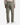 A person stands facing away against a plain white background, wearing PROJEK RAW SPONGEE BUNGEE LOOSE FIT CHINO PANT in light olive green with back pockets, paired with a beige long-sleeve shirt and white sneakers.