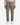 A person wearing the PROJEK RAW SPONGEE BUNGEE LOOSE FIT CHINO PANT in olive green, paired with a beige shirt and white sneakers, stands against a plain white background.
