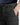 A close-up of a person wearing PROJEK RAW PLAID BUNGEE CLASSIC FIT CHINO PANTS, with one hand in their pocket, highlighting the black button and part of a dark blue shirt above the waistband.