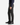 A person wearing PLAID BUNGEE CLASSIC FIT CHINO PANTS by PROJEK RAW, styled with a navy long-sleeve shirt and black dress shoes, stands against a white background.