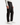 A person is shown from the waist down wearing PROJEK RAW’s PLAID BUNGEE RELAXED FIT CHINO PANTS, paired with a white long-sleeve shirt and white sneakers, standing against a plain white background.