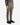A person is shown from the waist down, standing against a plain white background and wearing PROJEK RAW CANVAS BUNGEE RELAXED FIT CARGO PANTS in olive green, paired with a gray button-up shirt and black sneakers.