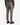 A person is shown standing with their back to the camera against a white background, wearing PROJEK RAW CANVAS BUNGEE RELAXED FIT CARGO PANTS in olive green. The pants feature back pockets and a side cargo pocket, paired with a long-sleeve gray shirt and black sneakers.