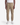 A person wearing the PROJEK RAW CANVAS BUNGEE CLASSIC FIT PULL ON JOGGER in tan, styled with a white t-shirt and white sneakers, stands facing forward against a plain white background.