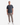 A man stands facing forward against a plain white background, wearing a charcoal gray short-sleeve t-shirt, white sneakers, and PROJEK RAW’s KNIT CAVALRY TWILL RELAXED FIT CHINO PANTS in taupe.