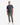 A man stands facing forward against a plain white background wearing a dark gray t-shirt, white sneakers, and olive green KNIT CAVALRY TWILL RELAXED FIT CHINO PANTS by PROJEK RAW.