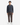Certainly! Here’s your refined description incorporating the product details: A person stands facing forward against a plain white background, dressed in a dark quarter-zip sweater, white sneakers, and brown PROJEK RAW CORDUROY RELAXED FIT CHINO PANTS.