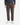 Wearing PROJEK RAW’s CORDUROY RELAXED FIT CHINO PANTS in a brown pinstriped design, paired with a navy long-sleeve top and white sneakers, the individual stands against a plain white background. The photo focuses on the lower body, showcasing the modern silhouette of these chinos.