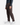 A person wearing PROJEK RAW CORDUROY RELAXED FIT CHINO PANTS, a dark long-sleeve shirt, and white sneakers poses confidently against a plain white background.
