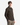 A young man with short brown hair, facing forward with his hands in his pockets against a plain white background, wears the PROJEK RAW MEN’S 24/7 BUTTON-UP MODERN FIT KNIT SHIRT in dark brown, paired with khaki pants. The shirt features a wrinkle-resistant design for lasting style.