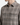 A person wearing the PROJEK RAW PLAID CORDUROY SHIRT—a gray, plaid-patterned button-up with two chest pockets—is photographed from the shoulders to mid-torso against a plain background. This relaxed fit shirt is a true wardrobe essential.