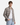 A young man models the PROJEK RAW PLAID CORDUROY SHIRT in beige, layered over a white T-shirt and paired with light blue jeans, standing with one hand in his pocket and facing the camera against a plain white background.