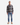 A man faces forward against a plain white background, wearing the PROJEK RAW PLAID FLANNEL SHIRT as a stylish layering piece, paired with light blue jeans and beige boots.