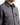 A person is shown from the shoulders to the chest against a plain background, wearing the PROJEK RAW KNIT CAVALRY TWILL OVERSHIRT in dark gray, featuring two chest pockets and a collar.