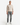 A man stands facing forward against a plain white background, wearing the PROJEK RAW CLASSIC FIT CHENILLE CREWNECK SWEATER, paired with gray jeans and white sneakers.