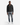A man stands facing forward against a plain white background, wearing the PROJEK RAW BONDED CHENILLE ZIP-UP HOODIE in black as a cozy layer over a white shirt, paired with faded blue jeans and white sneakers.