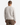 A person with short hair is standing, facing away, wearing the PROJEK RAW HONEYCOMB CHENILLE SWEATER—a cozy white crewneck sweater—paired with brown trousers against a plain white background, perfect for any casual wardrobe.