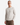 A man with a neutral expression wears the PROJEK RAW HONEYCOMB CHENILLE SWEATER in textured light beige, paired with brown pants and standing against a plain white background—a cozy essential for any casual wardrobe.