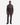 A man stands facing forward against a plain white background, wearing the PROJEK RAW BONDED CHENILLE 1/4″ ZIP PULLOVER SWEATER in dark gray with brown stripes, paired with brown pants and black shoes.