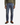 A person wearing a green sweater, the PROJEK RAW BARU CLASSIC STRAIGHT FIT DENIM in washed indigo with classic 5-pocket styling, and brown leather boots stands against a white background, shown from shoulders to feet.