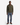 A man stands facing forward against a white background, wearing an olive green quarter-zip sweater, brown boots, and PROJEK RAW’s BARU CLASSIC STRAIGHT FIT DENIM in washed indigo.