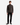 A person stands facing forward against a plain white background, wearing the PROJEK RAW BARU CLASSIC COLORED KNIT DENIM jeans, paired with a dark textured quarter-zip sweater and black shoes.