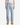 A person models the PROJEK RAW DREW BAGGY FIT DENIM in retro blue, styled with a white sleeveless shirt and tan boots, standing facing forward against a plain white background.