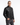 A man wearing the PROJEK RAW MEN’S VEGAN LEATHER MOTO JACKET in sleek black and dark gray jeans stands with one hand in his pocket against a plain white background, looking directly at the camera.