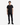 A person stands facing forward, wearing the PROJEK RAW LUX ESSENTIAL JERSEY T-SHIRT in black, paired with black pants and black lace-up boots against a white background—an urban essential look for men’s casual style.