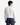 A person with short dark hair is seen from the back, wearing the PROJEK RAW RELAXED FIT HONEYCOMB CREWNECK SWEATER in white paired with blue jeans, standing against a plain, light background.