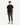 A person stands facing forward against a white background, wearing the PROJEK RAW CREWNECK SCUBA T-SHIRT—a versatile plain black crew neck tee with a soft hand feel—paired with olive green pants and tan lace-up boots.