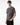 A young man with short brown hair wears the PROJEK RAW Printed Cotton Single Jersey T-Shirt, featuring a gray marble pattern, paired with black pants and standing against a plain white background.