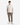 A person stands facing forward, wearing the PROJEK RAW COTTON BLEND LONG SLUB T-SHIRT in plain white, paired with light brown jogger pants with pockets and white sneakers, against a plain white background.
