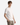 A young man with light brown hair is wearing a plain white PROJEK RAW COTTON BLEND LONG SLUB T-SHIRT paired with light brown pants, standing with one hand in his pocket against a plain light gray background.