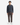 A person stands facing forward, wearing the PROJEK RAW RELAXED FIT KNIT CORD PULLOVER SWEATER, paired with brown pants and white sneakers, embodying a casual streetwear look against a plain white background.