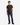 A person stands facing forward against a plain white background, wearing the PROJEK RAW KNIT CORD RELAXED FIT CREWNECK in dark brown, paired with blue jeans and black shoes.