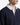 A man is seen wearing the PROJEK RAW RELAXED FIT FRENCH TERRY RUGBY SWEATER, featuring a navy blue hue with a buttoned white collar. Made from soft French terry in a relaxed fit, only his lower face, neck, and upper torso are visible against a plain background.