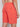 A person wearing Projek Raw’s DEVIN-CORAL shorts, featuring an elastic waistband and zippered back pocket, shown waist to mid-thigh from behind.