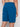 A person is shown from the waist down wearing Projek Raws DEVIN-OCEAN blue athletic shorts with an elastic waistband and a zippered back pocket, standing against a light background.