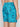 Someone wearing Projek Raws PATRICK-TURQUOISE swim trunks, featuring a vibrant tropical print, is shown from the waist down and viewed from behind.