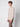 A young man with curly brown hair models the PROJEK RAW Mens Half-zip Cashmere Touch Sweater in light beige with brown pants, standing against a plain light gray background and gazing slightly to the side.