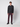 A young man stands against a light gray background, wearing a dark hooded sweater, PROJEK RAW Mens 5-pocket Classic Stretch Bungee Pants, and black shoes, looking straight at the camera with a neutral expression.